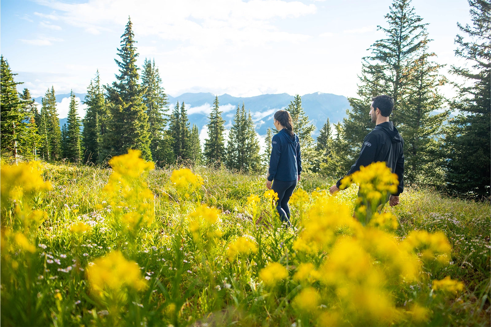 Two persons on a trail walk wearing Recover Brands Impact Jackets
